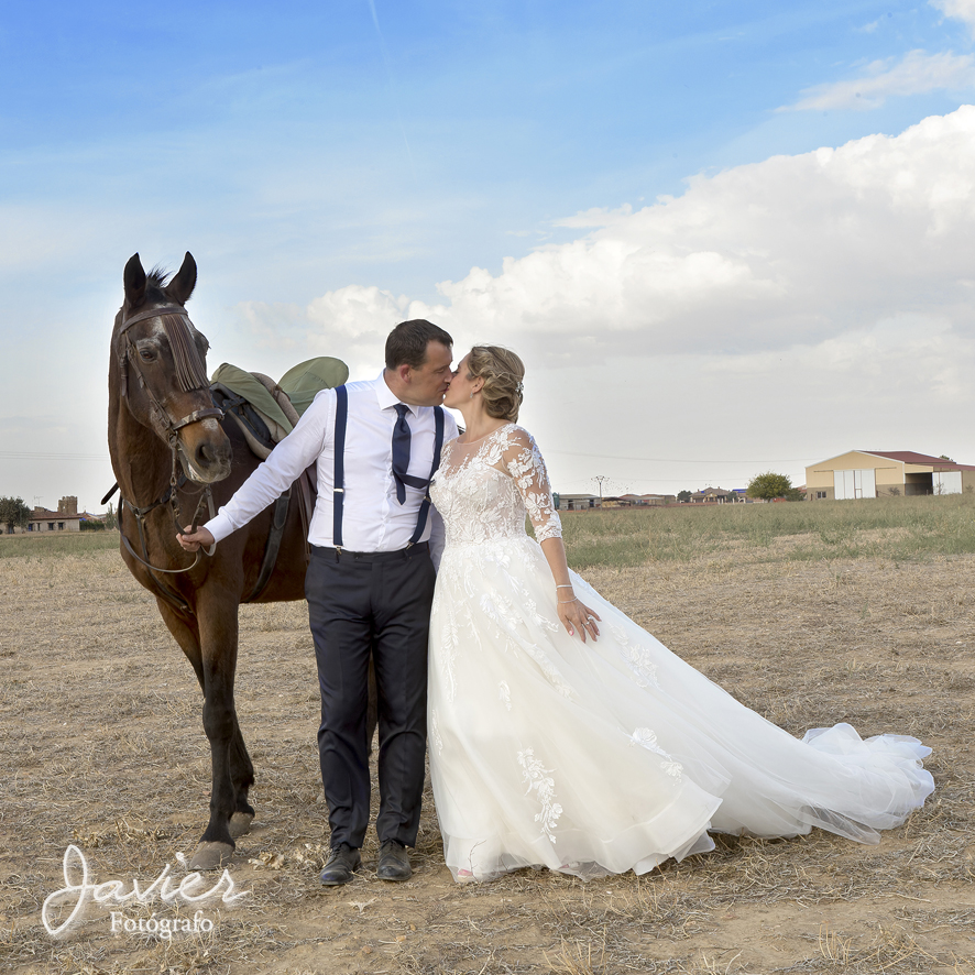 foto novios dándose un beso y un caballo