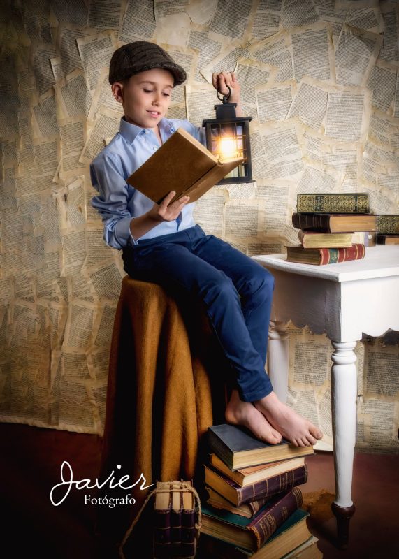 Niño de Comunión leyendo con farol en sesión de fotos en estudio en Valladolid