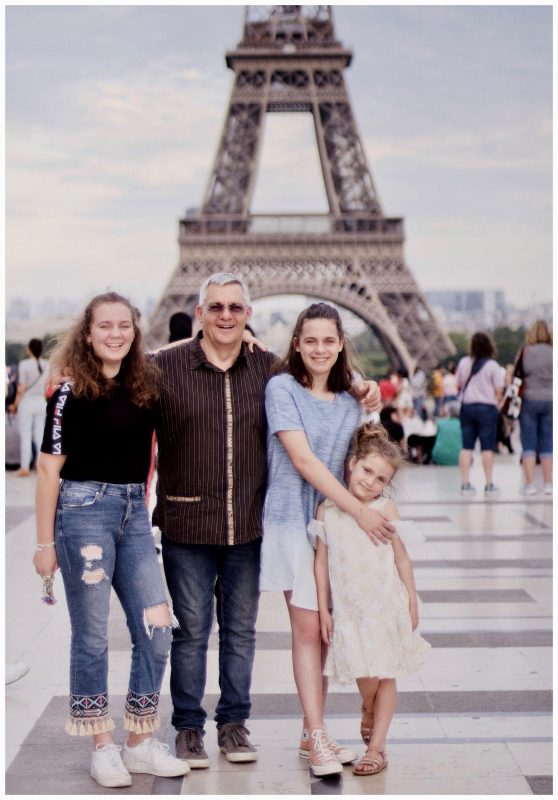 Familia posando frente a la Torre Eiffel durante un viaje a París.