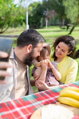Familia posando para una fotografía durante un picnic al aire libre