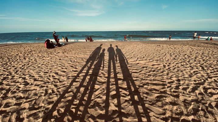 Sombras de una familia en la playa durante las vacaciones de verano